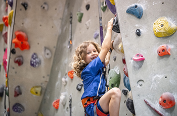 Young child climbing a rock wall